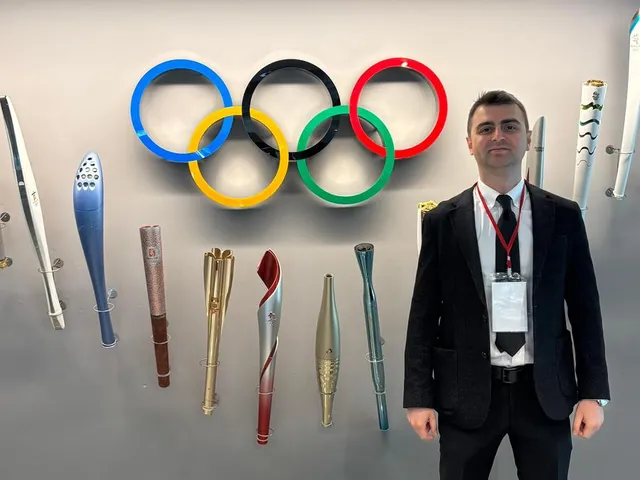 Dr. Mehmet Kaymakoğlu olimpiyat halkaları önünde poz verirken